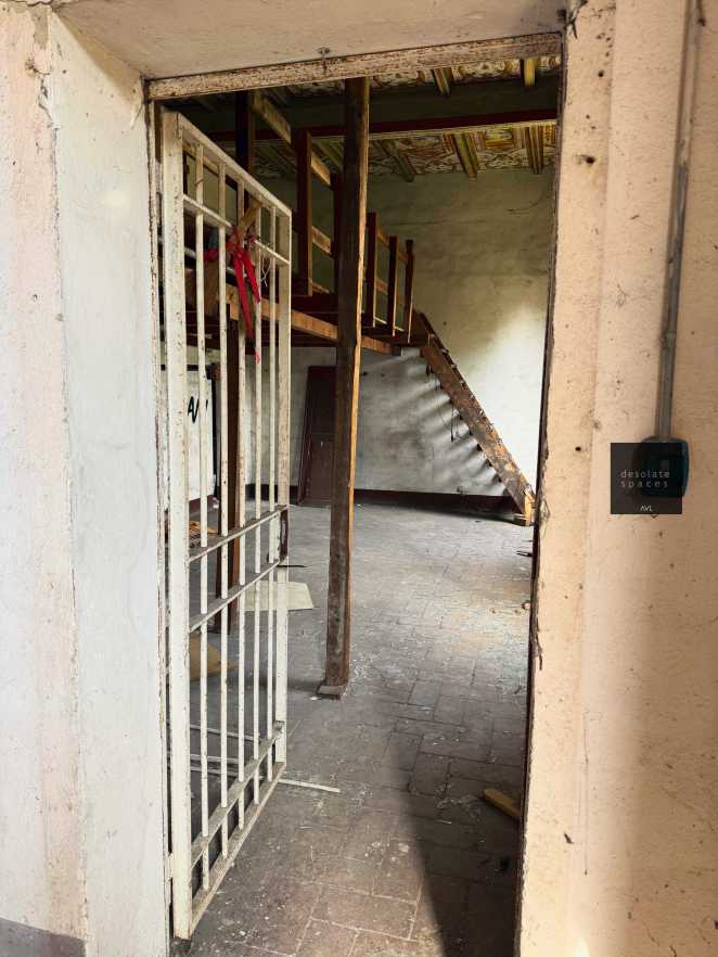Entrata di un edificio abbandonato con porte in metallo e scale di legno